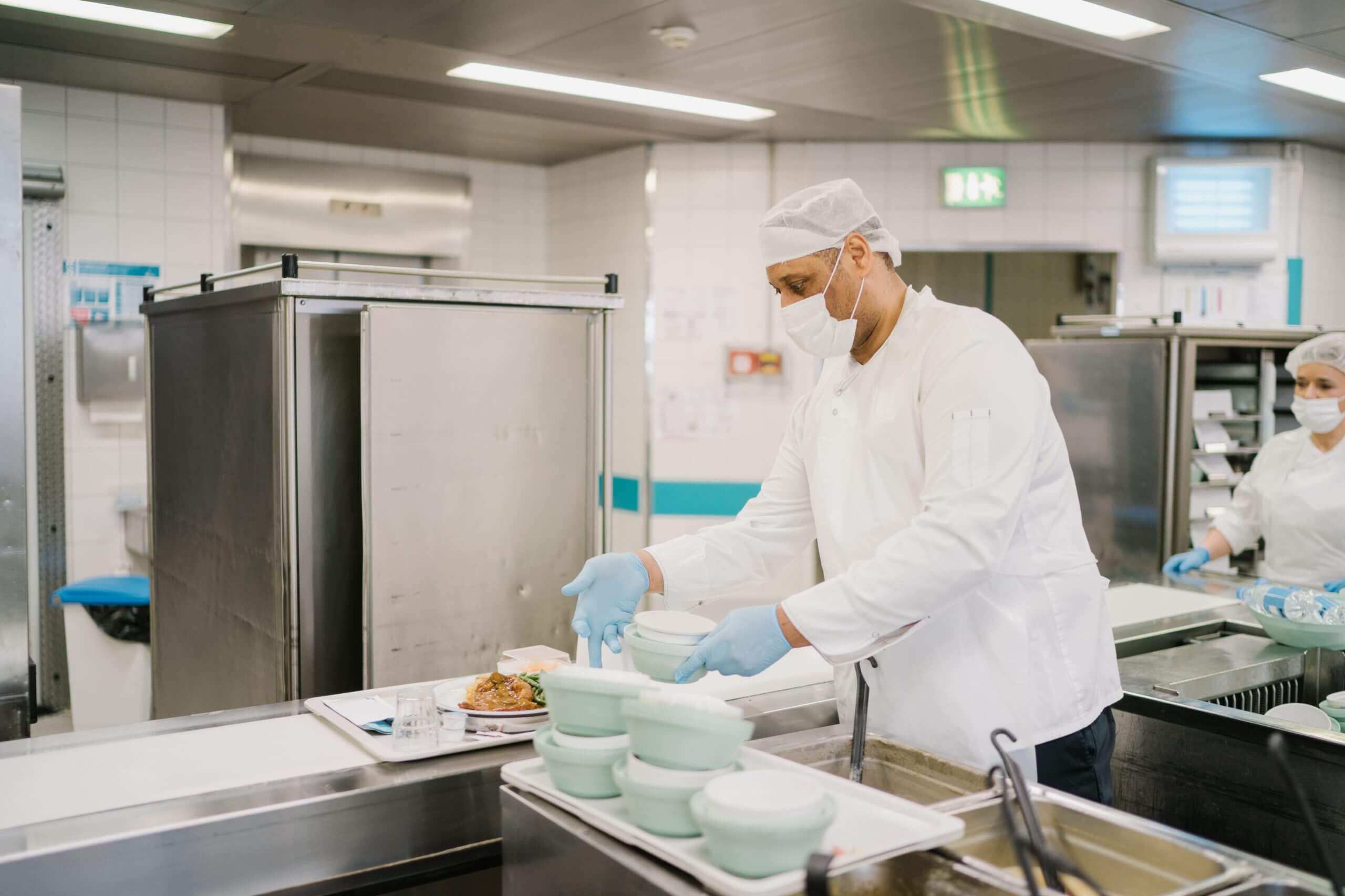 Distribution des repas en hôpital. Préparateur de plateau-repas en cuisine