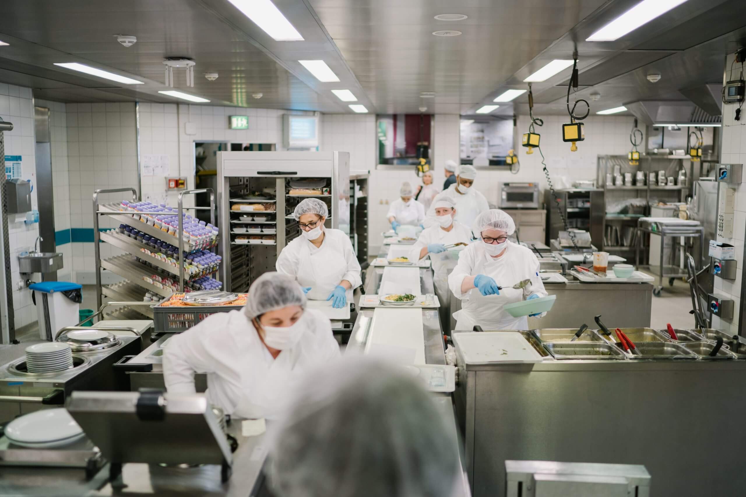 Distribution des repas en hôpital. Préparation des plateaux repas en cuisine.